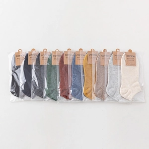 Set of 10 solid color cotton blend socks in individual packaging with kraft paper tags