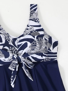 Detail view of V-neck tankini top with bow tie and blue abstract print pattern