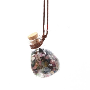 Detail of a glass wishing bottle with colorful crystal stones and a wooden cork stopper