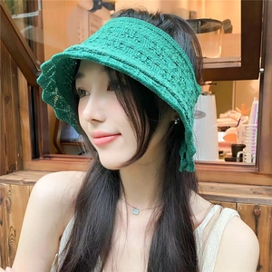 Dettaglio cappello parasole in maglia verde con bordi ondulati e design aperto