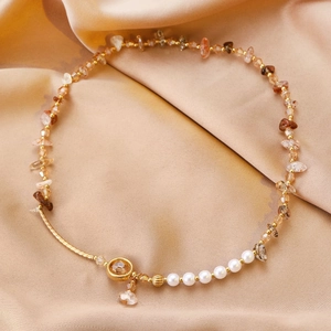 Détail d'un bracelet vintage avec perles en cristal naturel et pendentif papillon doré