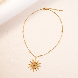 Gold stainless steel sun pendant necklace with elegant beaded chain on white background
