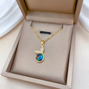 Elegant gold mermaid tail necklace with blue starry orb and sparkling pavé diamonds