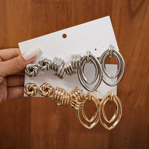 8-piece set of gold and silver minimalist metallic knot and spiral stud earrings on display card