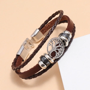 Detail of multi-layer woven brown leather bracelet featuring a silver tree of life charm
