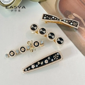 Detail view of retro rhinestone and pearl hair clips set in elegant gold finish