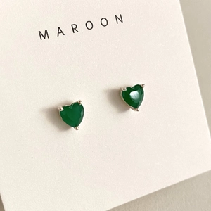 Macro shot of green heart-shaped cubic zirconia earrings in silver four-prong setting