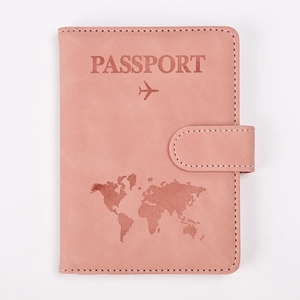 Detail of rose pink RFID passport holder featuring world map embossing and snap button