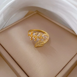 Macro shot of gold leaf ring with zircon stones in a luxury silk jewelry box