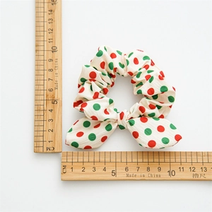 Polka dot Christmas scrunchie with rabbit ear bow design shown with measuring scales