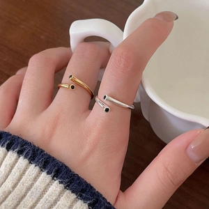 Minimalist adjustable silver ring with black enamel dots shown on model holding a cup