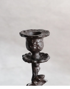 Gros plan du bougeoir rétro en fonte avec bords de pétales et texture bronze rustique