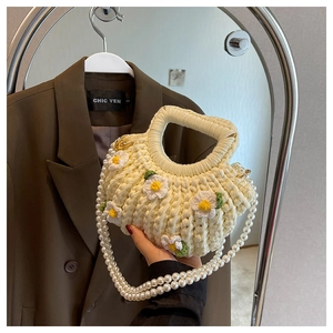 Detail of cream crochet handbag with 3D daisy flowers and elegant pearl chain strap