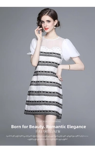 Close-up of black and white lace dress detailing with pearl embellishments and mesh