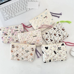 Detailed overhead view of assorted quilted cotton floral pouches with woven zip pulls