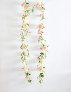 Detailed close-up of champagne artificial rose vine with green leaves for wall decoration