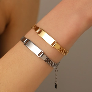 Close-up of gold and silver steel ID bracelets showing intricate woven mesh chains