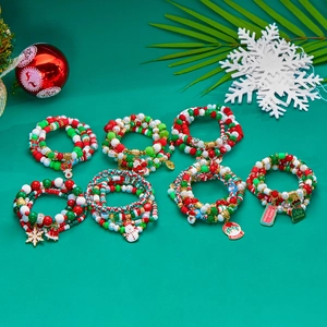 Christmas beaded bracelet set with Santa and snowflake charms on green festive background