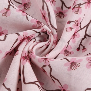 Gros plan sur le tissu en mousseline rose avec motif floral et texture délicate