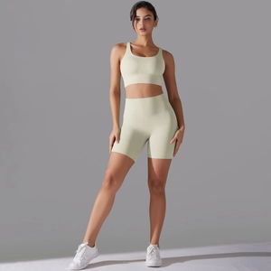 Dettaglio degli shorts da yoga a vita alta e reggiseno sportivo in tessuto beige traspirante