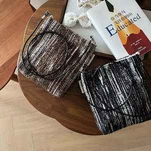 Vintage tweed crossbody phone bags in brown and black tones on a rustic wooden table