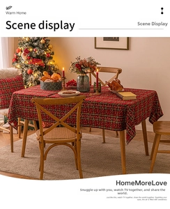 Detailed view of red and green plaid Christmas tablecloth with snowflake patterns and festive decor
