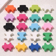 Detailed view of colorful puzzle piece charms in ten vibrant colors for DIY jewelry