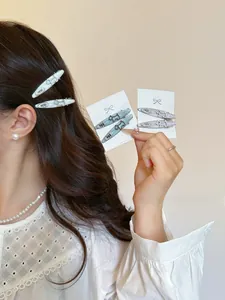 Detailed view of resin puppy hair clips featuring egg lettering and glitter finish