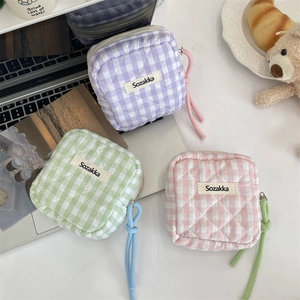 Set di mini borse portaoggetti trapuntate a quadretti in tonalità pastello su tavolo.