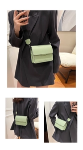 Detail view of mint green square crossbody bag with wide nylon strap and leather pad