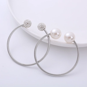 Silver twisted cable cuff bracelet featuring a large white pearl and a pave crystal ball