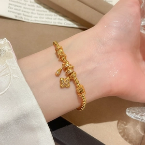 Macro detail of 24K gold plated flower pendant bracelet with delicate sparkling beads