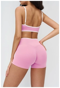 Rear view detail of a pink yoga set with white trim, highlighting the back strap design