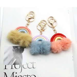 Detailed shot of bohemian rainbow tassel keychains with fluffy pom poms and gold ring