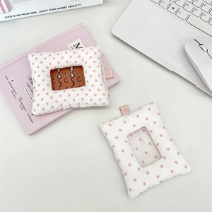 Close-up of cute plush photocard holders with star and polka dot patterns on desk