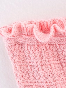 Macro shot of pink knit fabric texture featuring delicate ruffle edge detailing