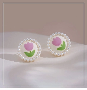 Detailed view of tulip pearl clip earrings on soft silk fabric background