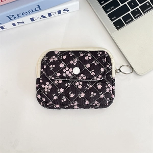 Detailed view of black floral quilted storage bag with zipper and snap-button flap pocket