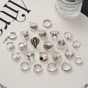 Detailed set of 23 Gothic silver rings with skulls, spiders, and punk motifs on vintage paper