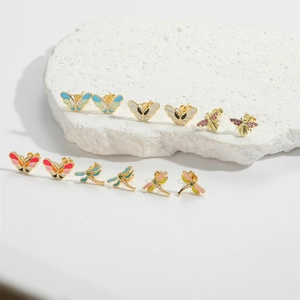 Minimalist colorful butterfly and dragonfly stud earrings set on white stone display