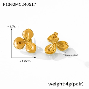 Macro view of gold flower stud earrings in titanium steel with detailed size markings