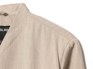 Detailed view of beige blazer neckline and inner brand label on smooth woven fabric