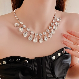 Gros plan d'un luxueux collier à pompons en forme de goutte argentée avec cristaux brillants