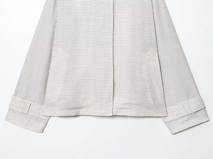 Détail de la veste courte à carreaux montrant la poche et le poignet ajustable