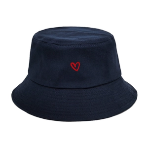 Close-up of red heart embroidery on a navy blue cotton bucket hat with stitched brim