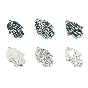 Polished stainless steel Hamsa hand charms with intricate cut-out patterns in silver and black