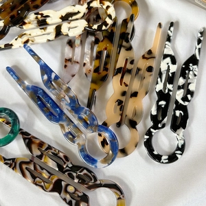U-shaped hair pins with marbled acetate texture and wavy double prong design for buns