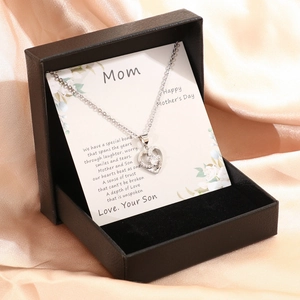 Silver-tone heart necklace with diamonds in black gift box on luxury silk background