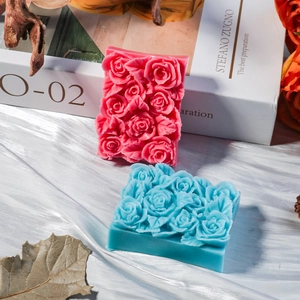 Dettaglio macro di stampi per sapone a cuore con rilievi di rose su seta bianca