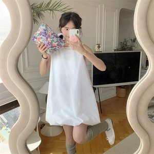 Detailed mirror selfie of a floral patterned cotton clutch bag paired with a white dress